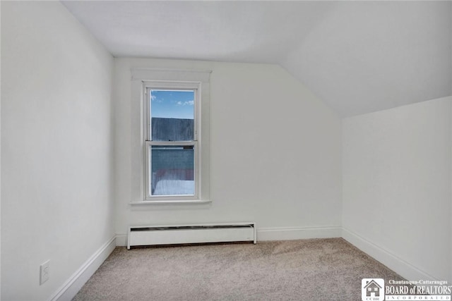 additional living space with light colored carpet, vaulted ceiling, and a baseboard heating unit