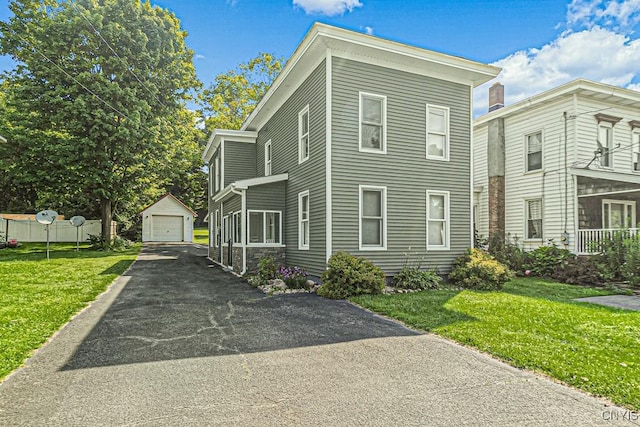 view of front of property with an outbuilding, a front lawn, and a garage