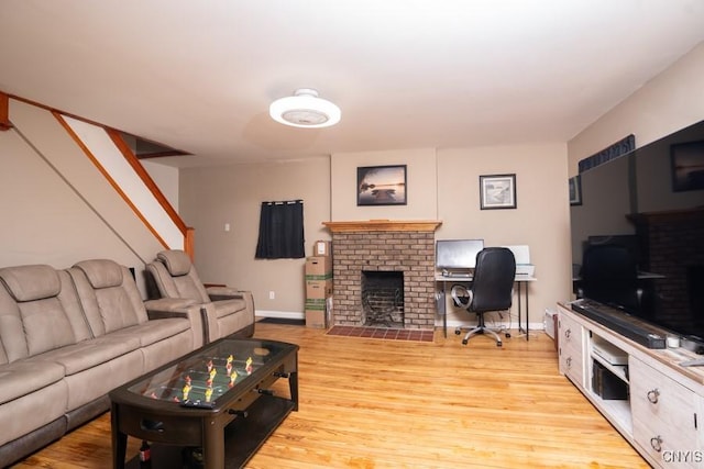 living room with light hardwood / wood-style floors and a brick fireplace