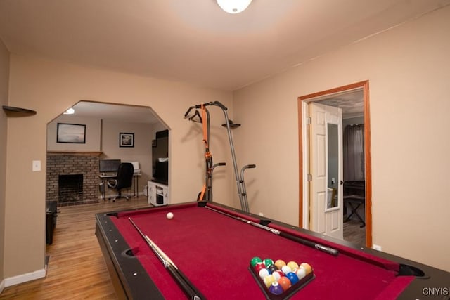 recreation room featuring hardwood / wood-style floors, pool table, and a brick fireplace