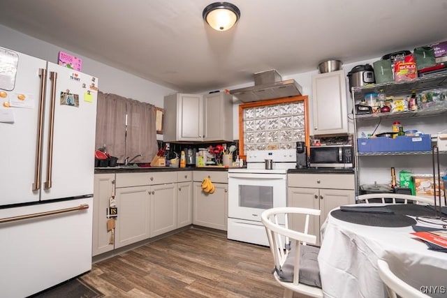 kitchen with tasteful backsplash, dark hardwood / wood-style flooring, wall chimney exhaust hood, and white appliances