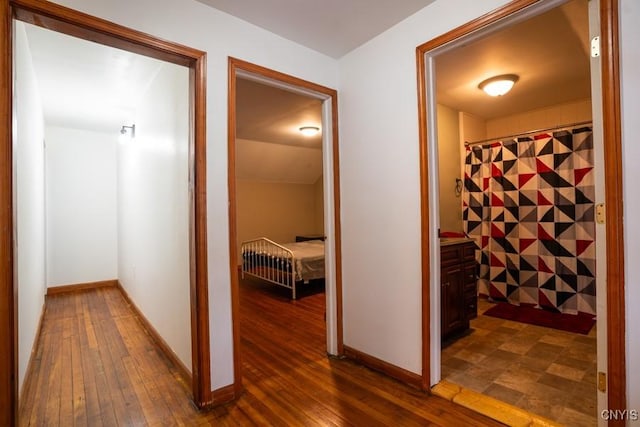 corridor with dark hardwood / wood-style flooring