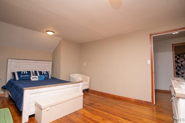 bedroom featuring hardwood / wood-style flooring and vaulted ceiling