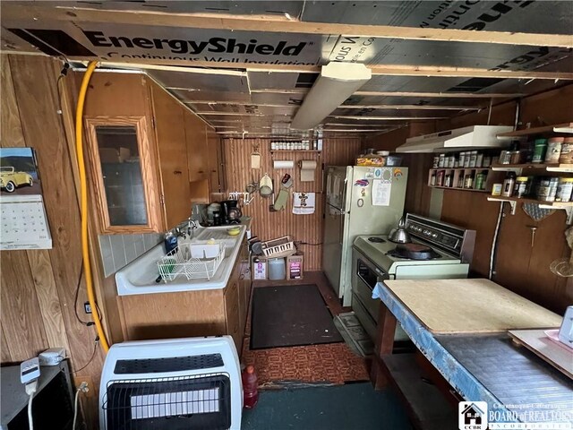 kitchen featuring heating unit, white fridge, range with electric stovetop, and wooden walls