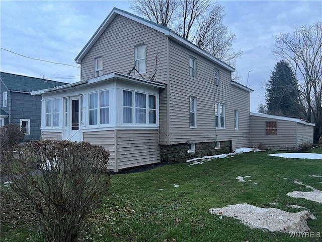 view of property exterior featuring a lawn and a sunroom