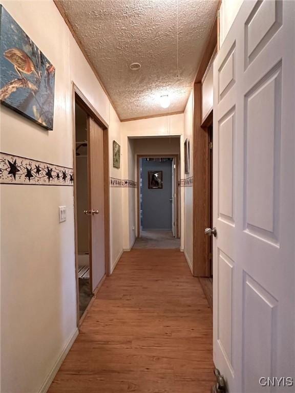 hall featuring vaulted ceiling, a textured ceiling, and hardwood / wood-style flooring