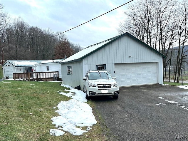 view of side of home featuring a yard, a garage, and a deck