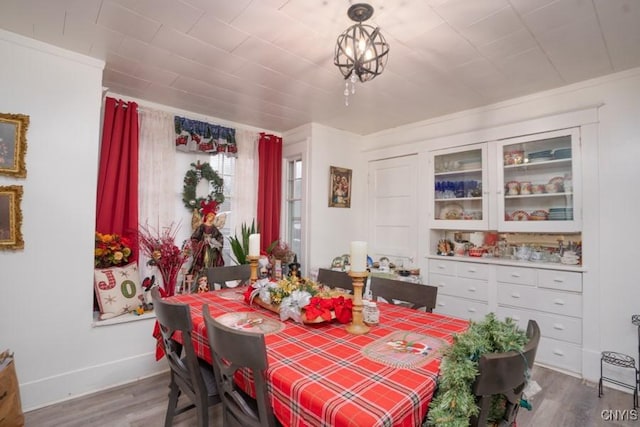 dining room with hardwood / wood-style flooring and ornamental molding