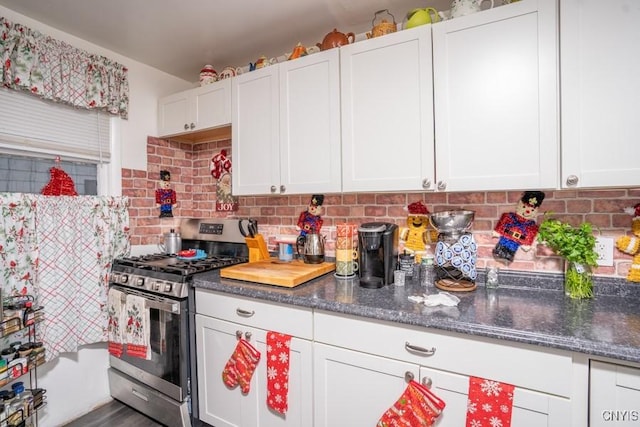 kitchen with gas stove, decorative backsplash, and white cabinets