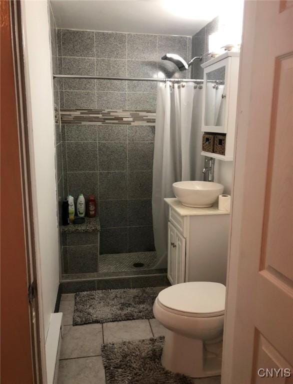 bathroom with toilet, vanity, tile patterned floors, and curtained shower