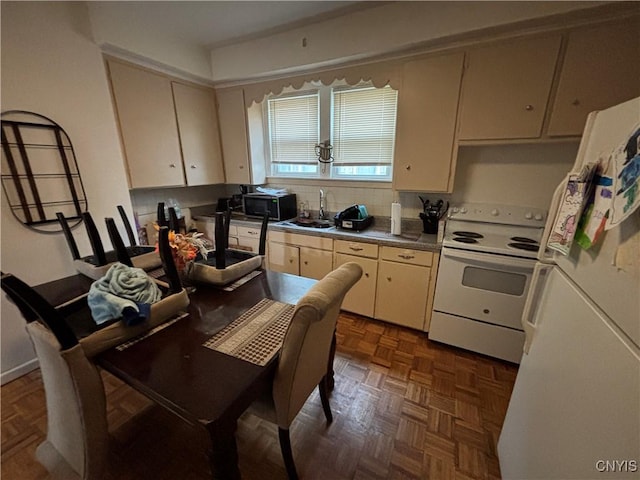 kitchen featuring dark parquet flooring, white appliances, sink, tasteful backsplash, and cream cabinetry