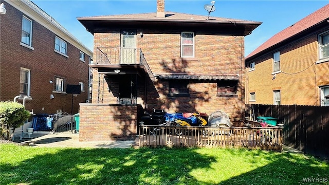 rear view of house featuring a yard and a balcony