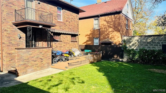 rear view of house featuring a yard and a balcony