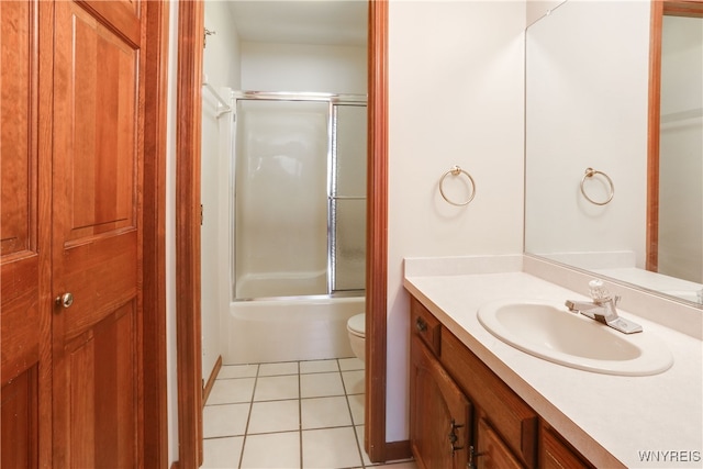 full bathroom featuring tile patterned floors, vanity, toilet, and enclosed tub / shower combo