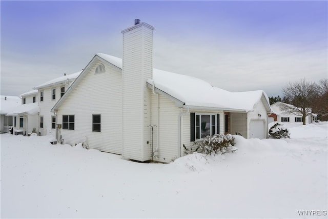 view of snowy exterior with a garage