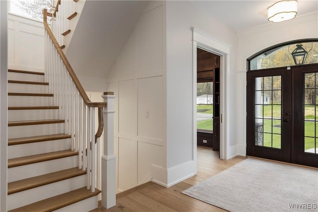 foyer entrance featuring french doors and light hardwood / wood-style flooring