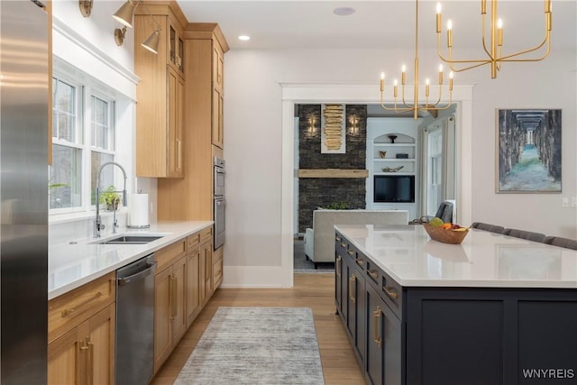 kitchen featuring pendant lighting, a center island, sink, appliances with stainless steel finishes, and a chandelier