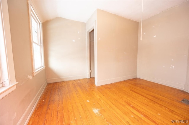 unfurnished room featuring wood-type flooring and vaulted ceiling