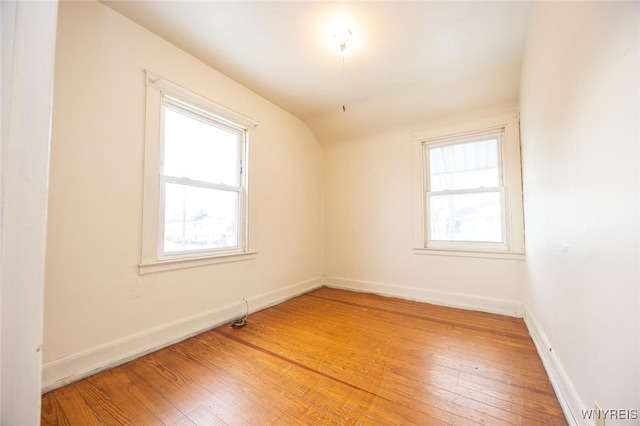 empty room with hardwood / wood-style flooring and a wealth of natural light