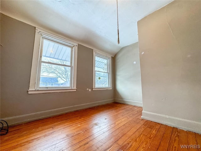 empty room with light wood-type flooring and lofted ceiling