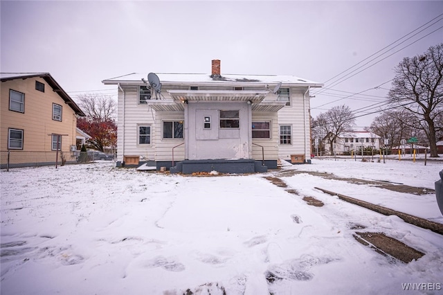 view of snow covered back of property