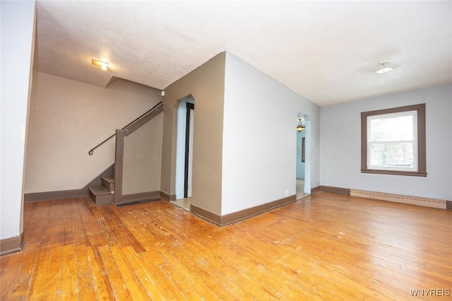 unfurnished room with a baseboard radiator and hardwood / wood-style flooring