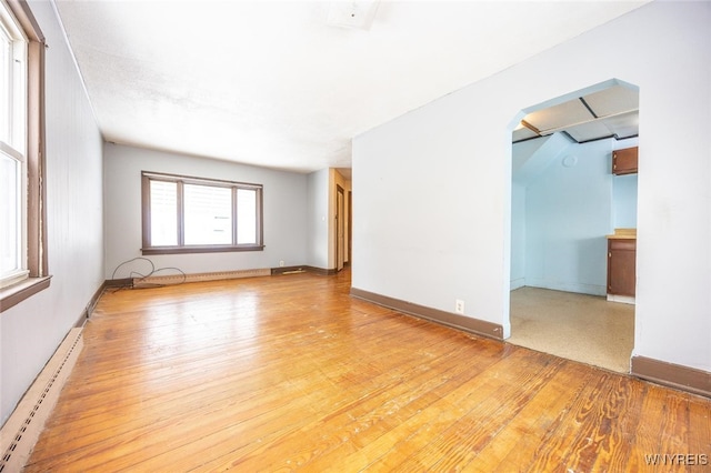 empty room featuring light wood-type flooring and baseboard heating