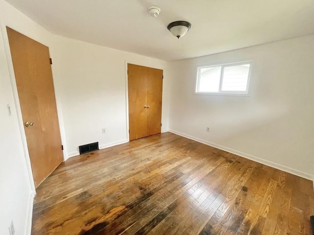 unfurnished bedroom with hardwood / wood-style flooring and a closet