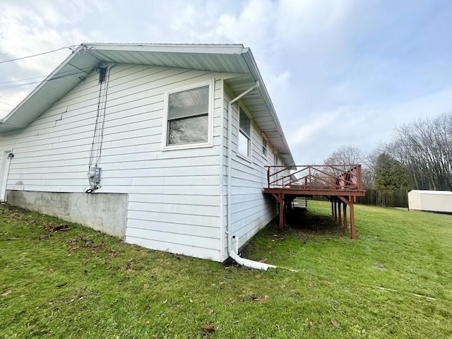 view of side of home featuring a yard and a wooden deck