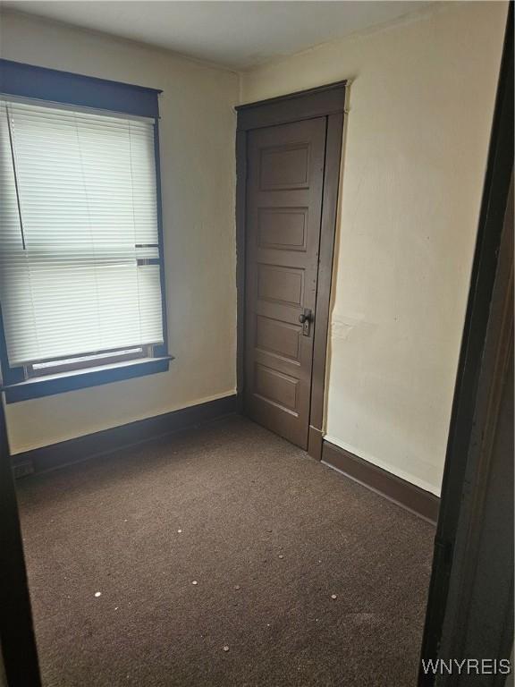 empty room featuring carpet flooring and baseboards
