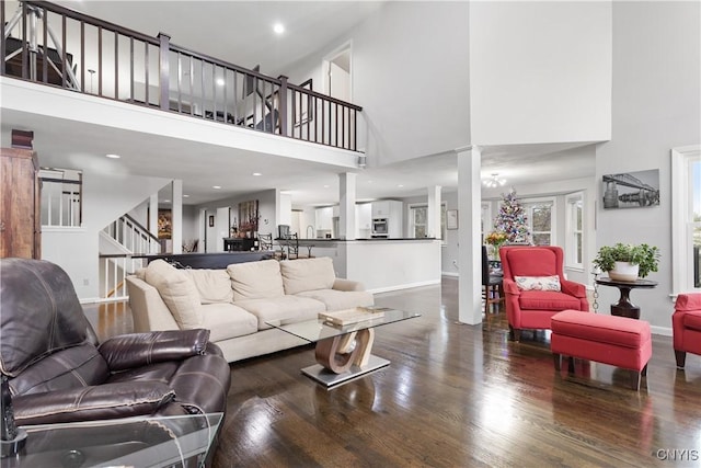 living room featuring a high ceiling and dark hardwood / wood-style flooring