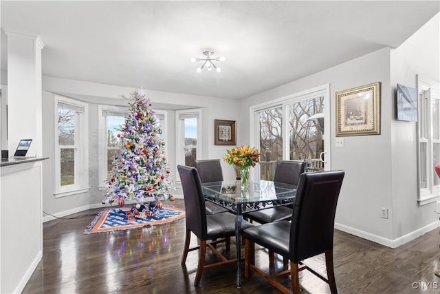 dining area featuring a wealth of natural light, dark hardwood / wood-style flooring, and a chandelier