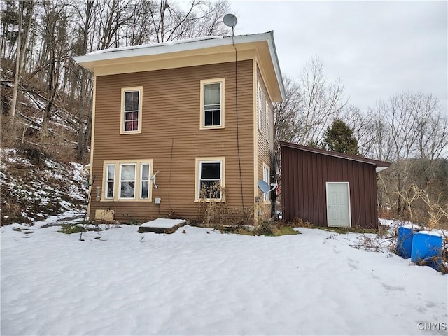 view of snow covered back of property