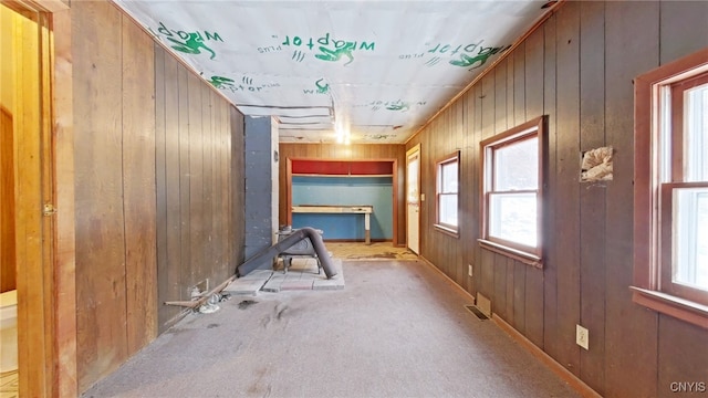 hallway with light colored carpet and wooden walls