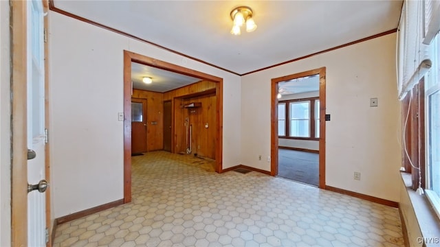 empty room featuring ceiling fan, crown molding, and wood walls