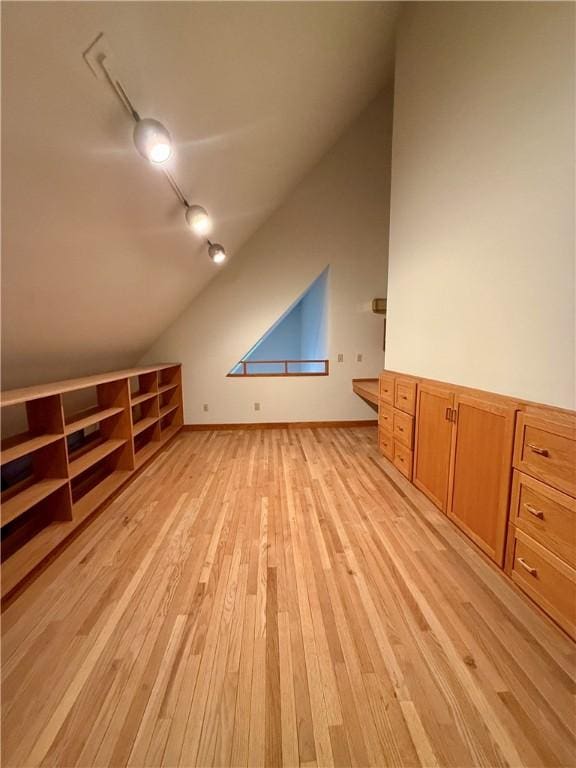 additional living space with light hardwood / wood-style floors and lofted ceiling