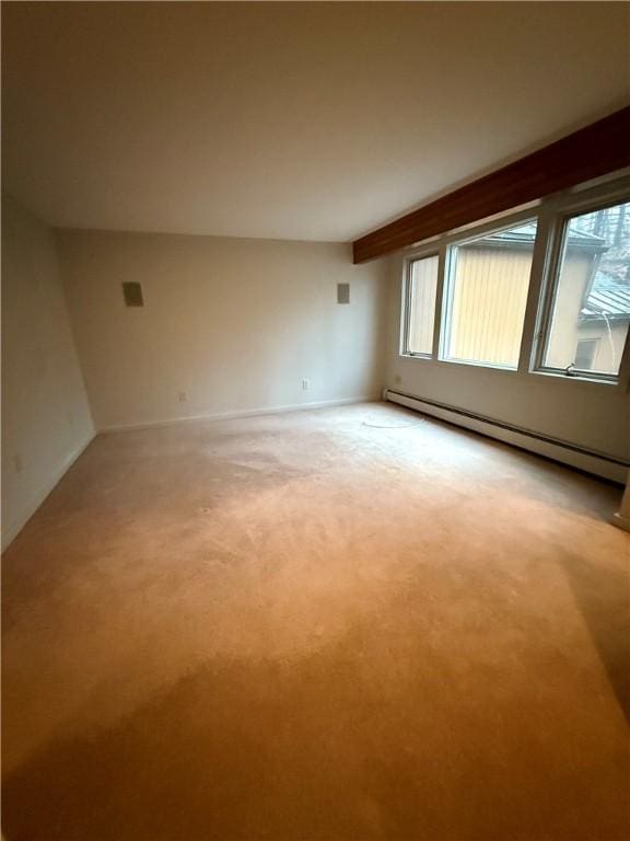 carpeted empty room featuring baseboard heating