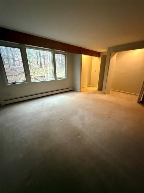 empty room with carpet, a wealth of natural light, and a baseboard radiator