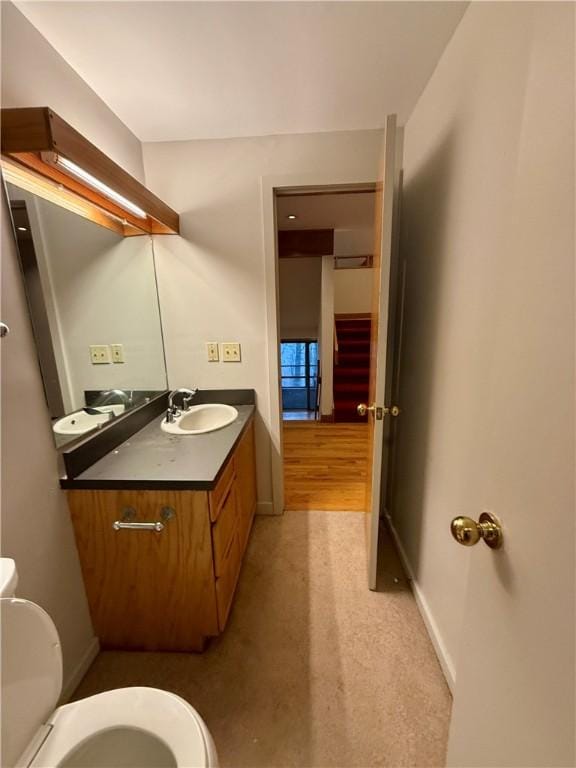 bathroom with hardwood / wood-style floors, vanity, and toilet