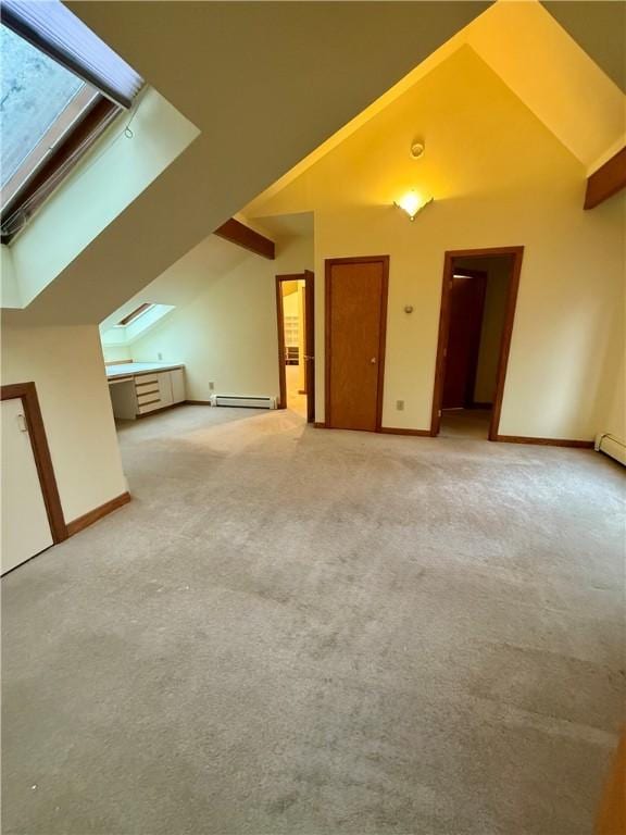 additional living space featuring lofted ceiling with skylight, baseboard heating, and light carpet