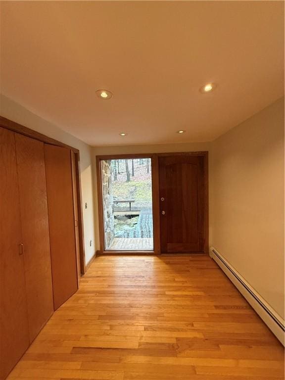 hall featuring a baseboard radiator and light hardwood / wood-style floors