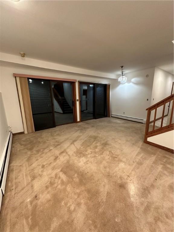 spare room featuring carpet flooring and a baseboard heating unit