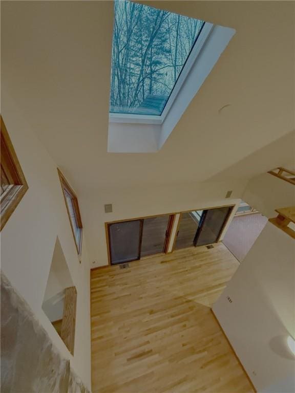 stairs featuring hardwood / wood-style floors and a skylight