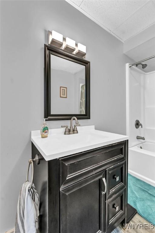 bathroom featuring shower / tub combination, vanity, hardwood / wood-style flooring, and a textured ceiling