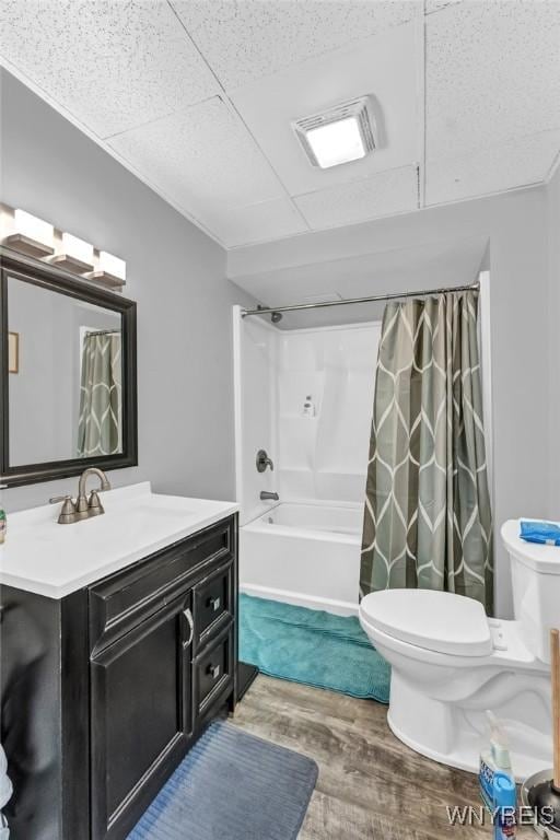 full bathroom featuring hardwood / wood-style floors, vanity, toilet, and shower / tub combo with curtain