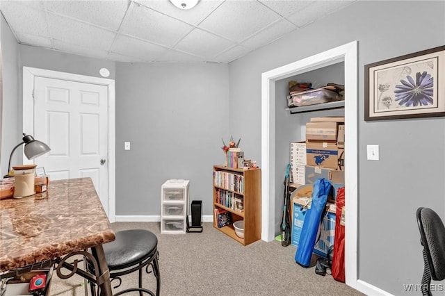 carpeted home office featuring a drop ceiling