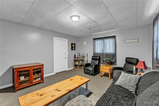 living room featuring carpet and a drop ceiling