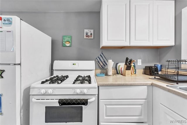 kitchen featuring white cabinetry and white appliances