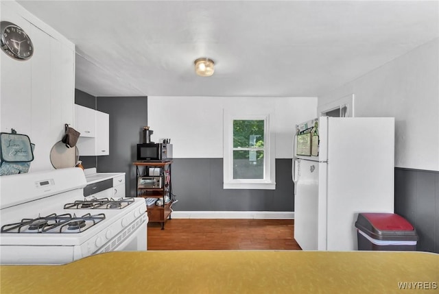 kitchen featuring white appliances, white cabinetry, and dark wood-type flooring