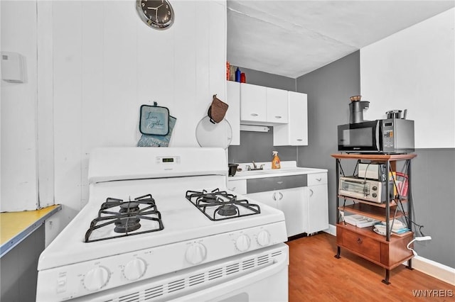 kitchen featuring light wood-type flooring, white cabinetry, sink, and gas range gas stove